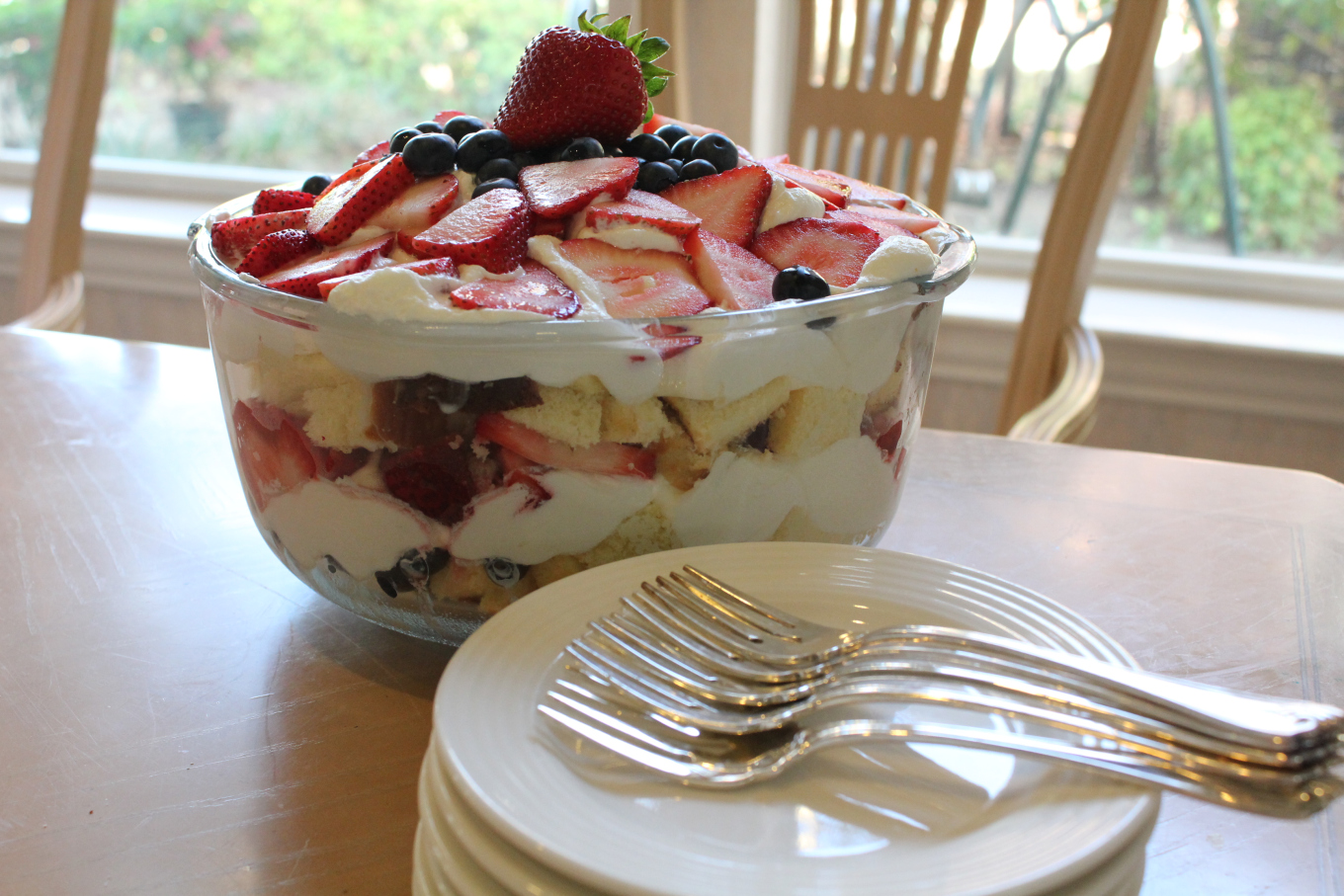 Red White and Blueberry Trifle on a table with plates and forks.