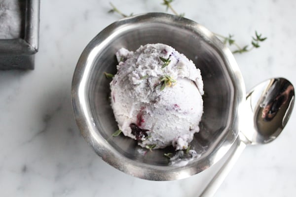 A scoop of Blueberry Lemon and Thyme Ice Cream in a dish.