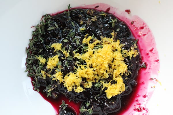 Blueberry compote, lemon zest, and thyme in a bowl for Blueberry Lemon and Thyme Ice Cream.