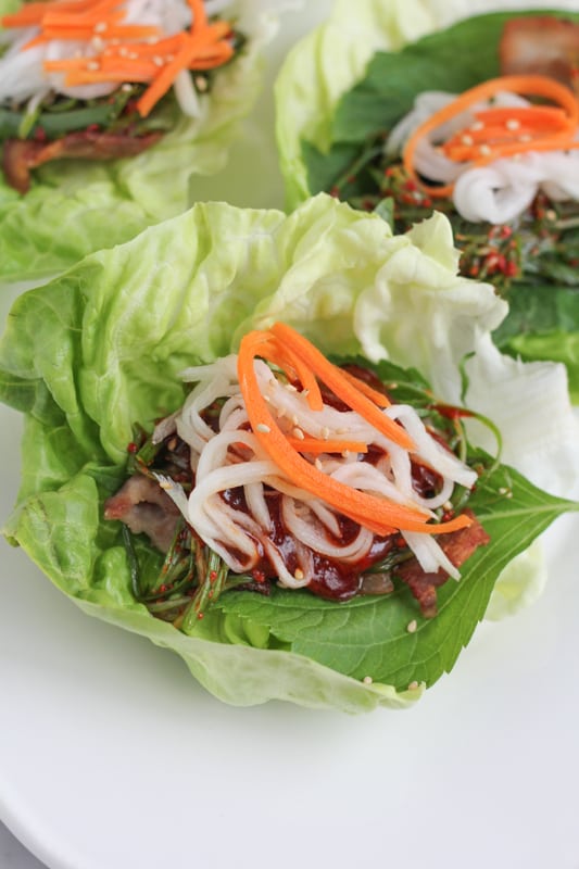 Pork Belly Lettuce Wraps topped with pickled vegetables.