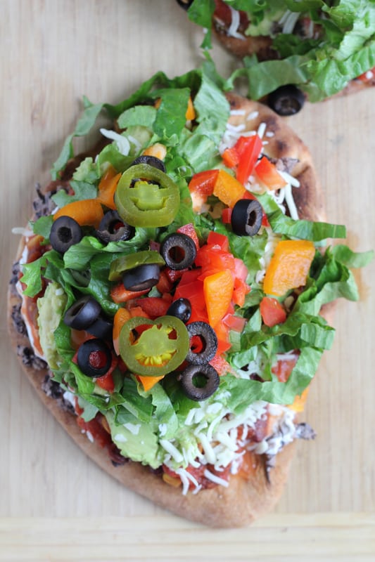 7 Layer Dip Flatbreads on a wood surface.