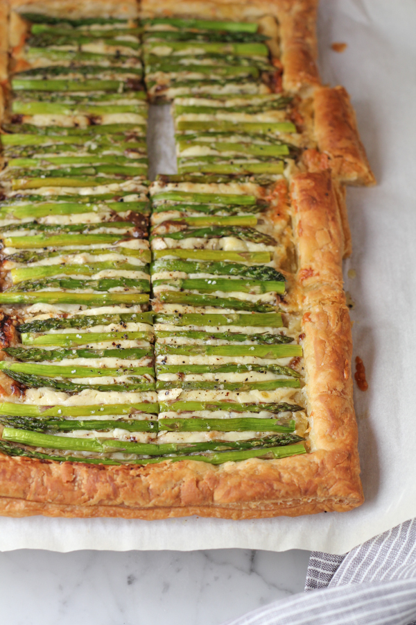 Sliced Asparagus Gruyere Tart on parchment paper.