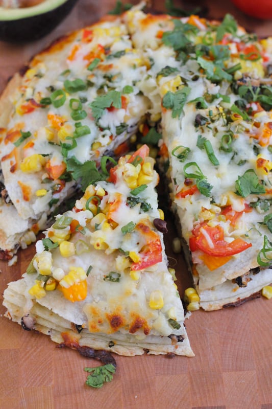 Sliced Corn and Black Bean Tortilla Tart on a wood cutting board.