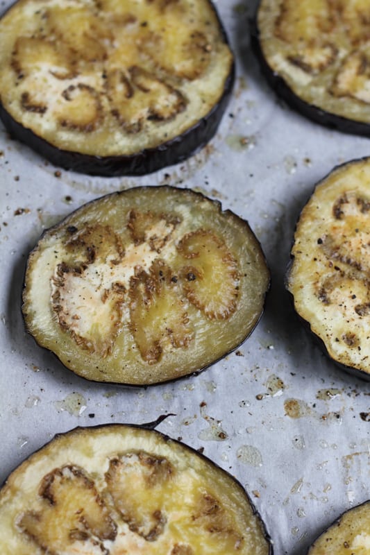 Slices of eggplant on a baking tray for Grilled Eggplant Bun Burger.