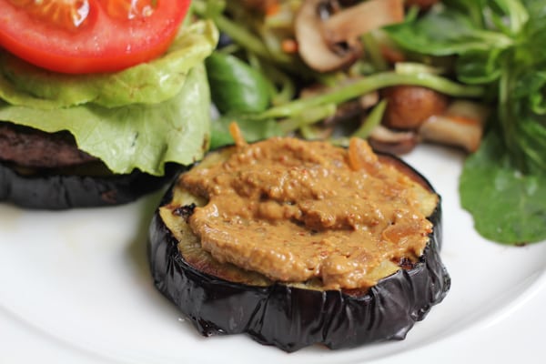 A slice of eggplant with mustard for Grilled Eggplant Bun Burgers.