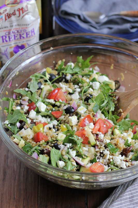A glass bowl of Mediterranean Freekeh Salad.
