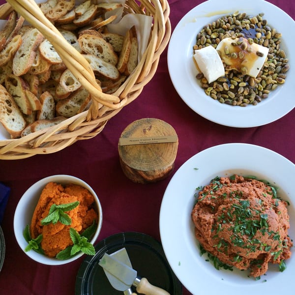 A basket of bread and appetizers on a table.