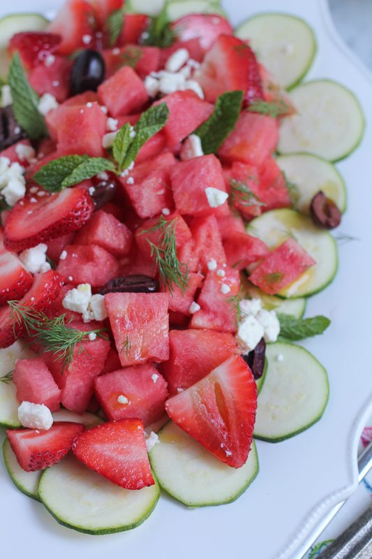 Zucchini watermelon and feta salad on a white plate.