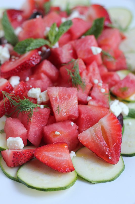 Zucchini watermelon and feta salad on a white plate.