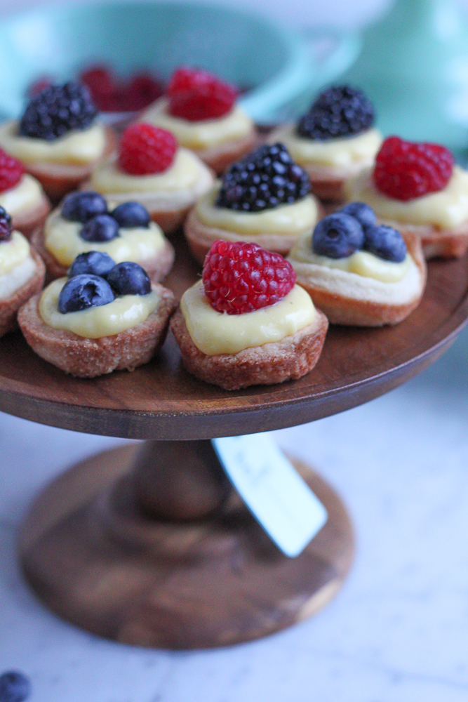 Mini Berry Tarts with Lemon Curd! Bite sized, easy to make and perfect for sharing with friends. The pastry shells are made with a new wheat flour and almond flour blend, so they are absolutely delicious!