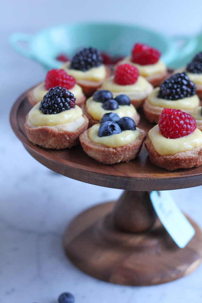Mini Berry Tarts with Lemon Curd! Bite sized, easy to make and perfect for sharing with friends. The pastry shells are made with a new wheat flour and almond flour blend, so they are absolutely delicious!