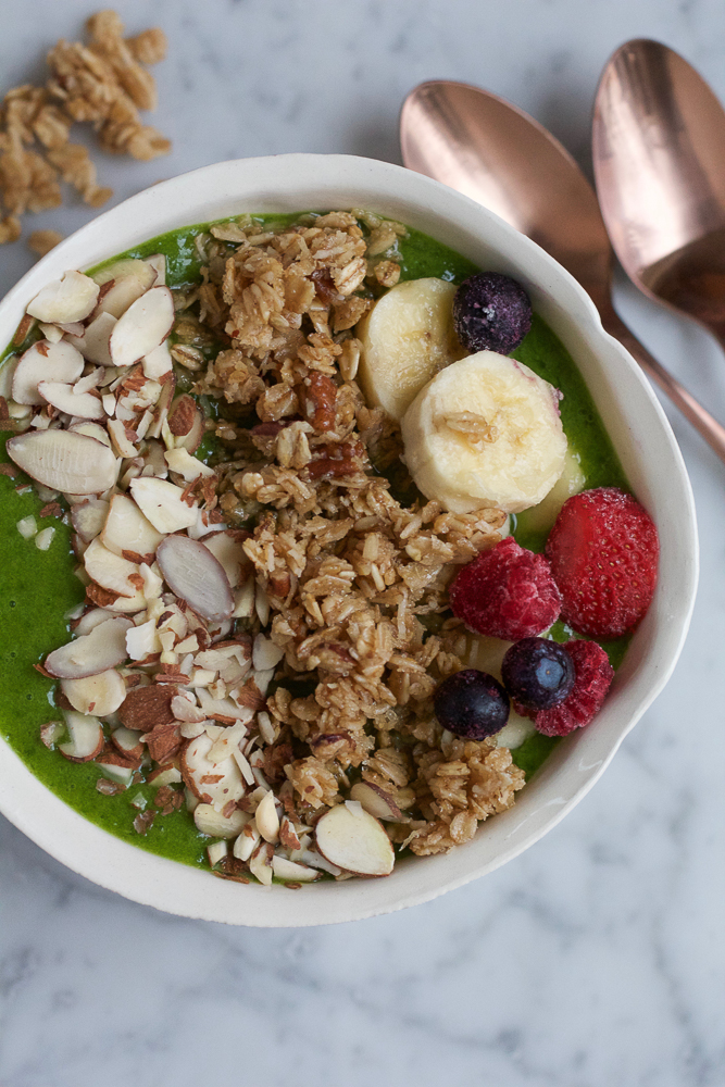 Banana Nut Granola Smoothie Bowl! Start off your morning the right way with this! A green spinach, flax and mango smoothie bowl topped with bananas, fresh berries, banana nut granola and almonds!