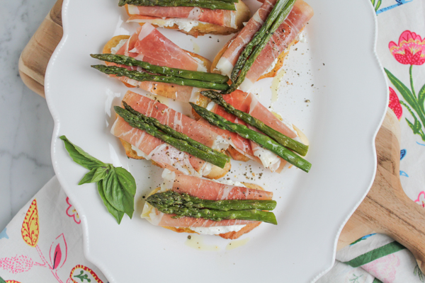 Roasted Asparagus and Prosciutto Crostini + A Video! Rich, creamy fresh ricotta cheese spread on toasted bread, topped with prosciutto and roasted asparagus. So EASY and makes an absolutely delicious appetizer!
