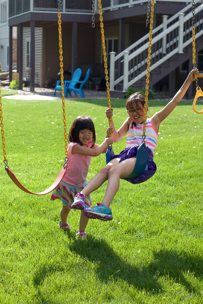Two children playing on swings.