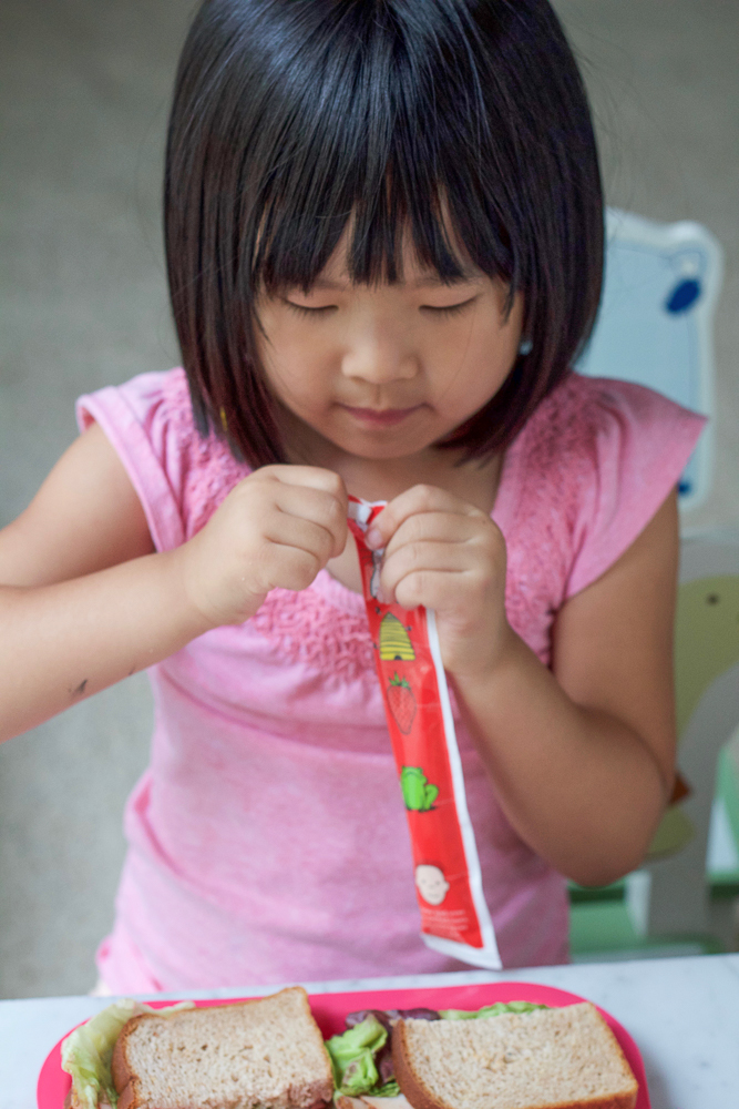 Opening a yogurt tube used for Frozen Berry Yogurt Bites.