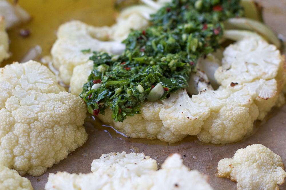 Grilled Cauliflower Steaks topped with chimichurri sauce.