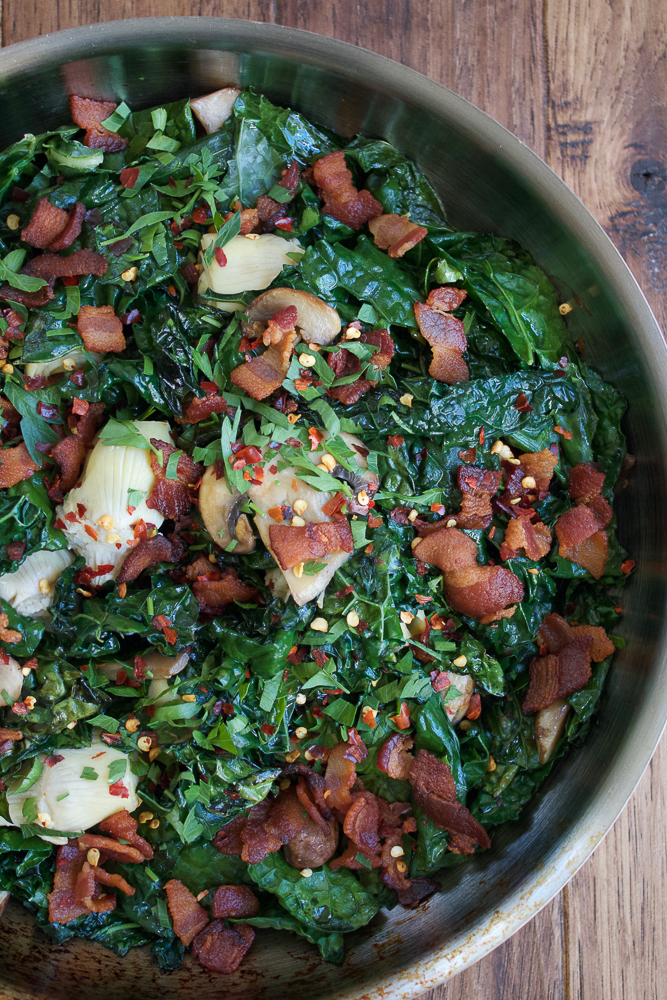 Warm Artichoke Salad! Wilted and warm kale greens mixed with artichokes, mushrooms and bacon, this warm artichoke salad is so delicious.