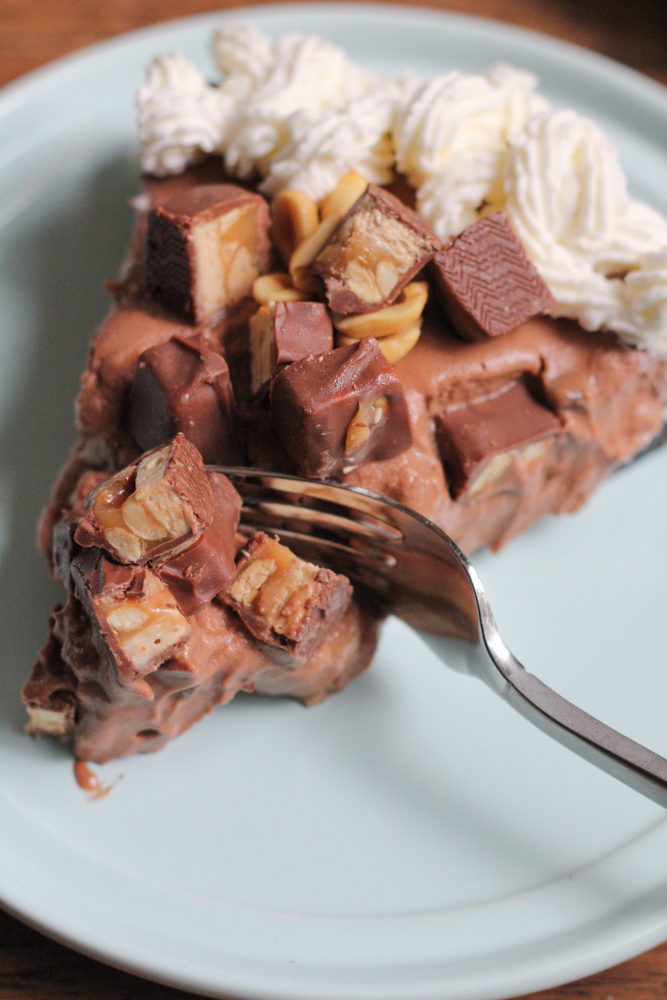 Hot Mess Nutella Snickers Pie!!! A creamy Nutella filling loaded with crushed peanuts and mini chocolate chips and topped with peanuts, whipped cream and bits of Snickers! This no bake pie is dessert heaven! From the cookbook, No-Bake Treats by Julianne Bayer.