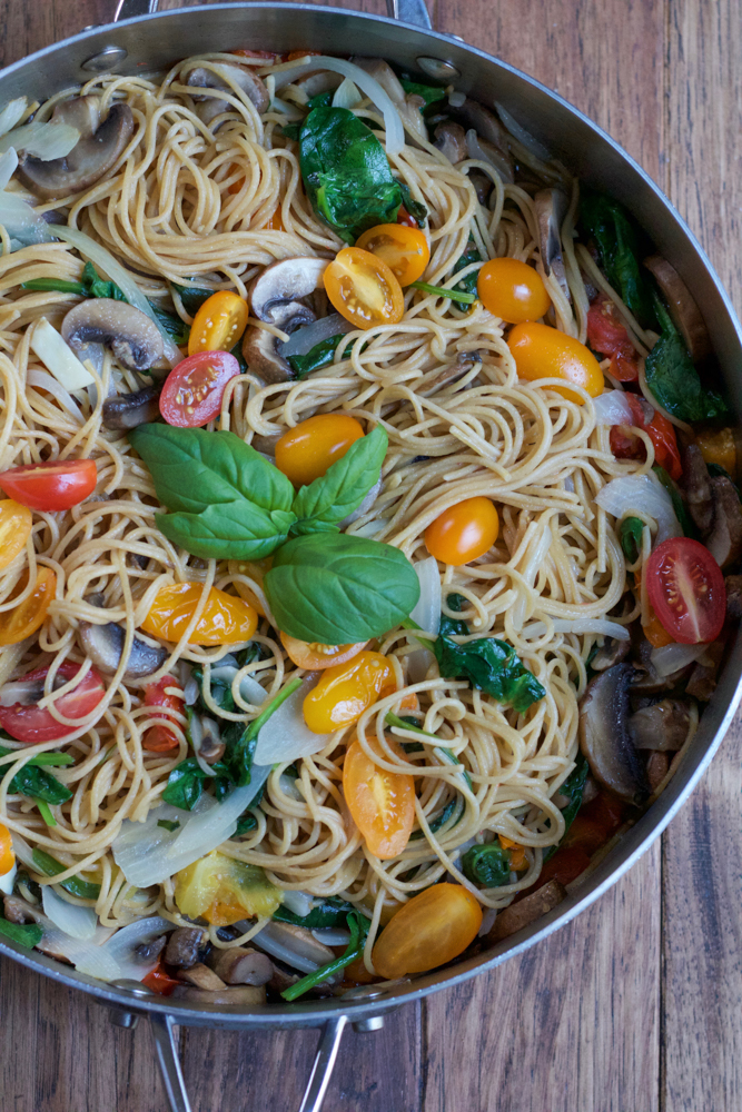 One Pot Pasta garnished with fresh basil in a pot.