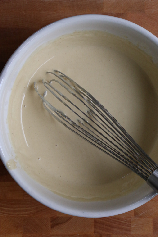 A bowl of dipping sauce with a whisk for Chicken and Veggie Spring Rolls.