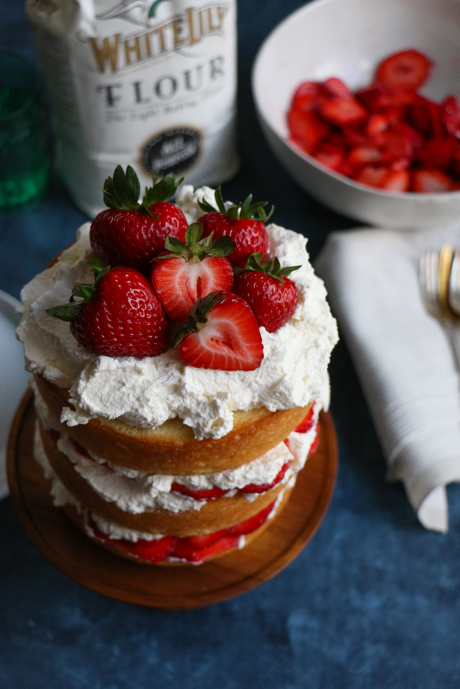 Strawberry Layer Cake with fresh homemade whipped cream and strawberries! Fresh, light and delicious! This is sure to be a show stopper at any party or special gathering!