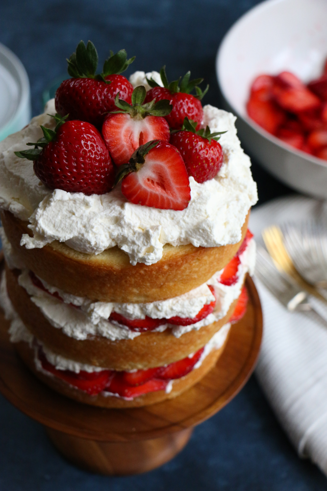 Strawberry Layer Cake with fresh homemade whipped cream and strawberries! Fresh, light and delicious! This is sure to be a show stopper at any party or special gathering!
