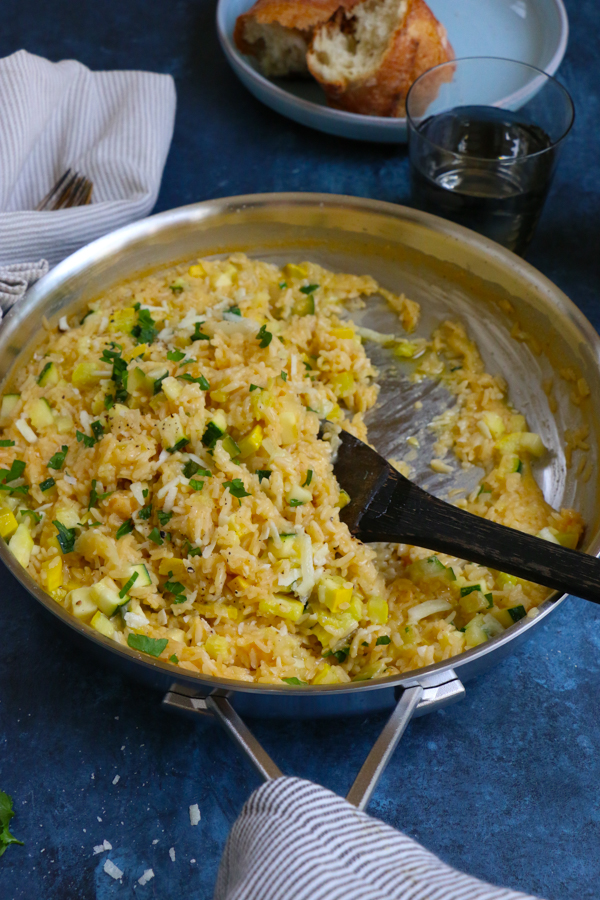 Four cheese risotto in a pan with a wooden spoon.