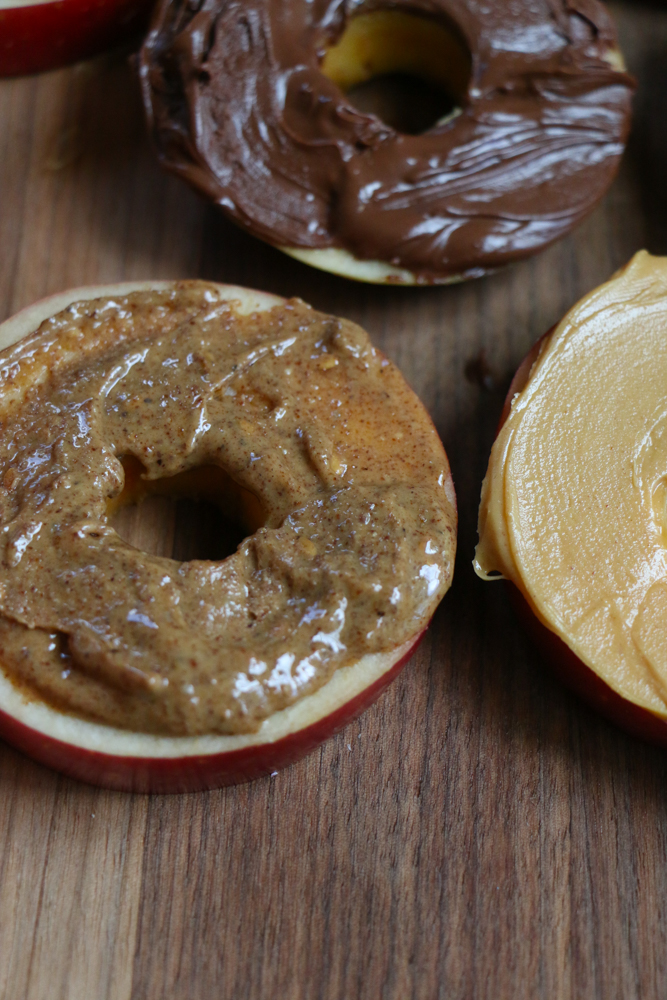 Cereal Apple Donuts! Fresh apple slices topped with peanut butter and almond butter and some of our favorite cereals from General Mills! The perfect summer snack!