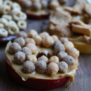 Cereal Apple Donuts! Fresh apple slices topped with peanut butter and almond butter and some of our favorite cereals from General Mills! The perfect summer snack!