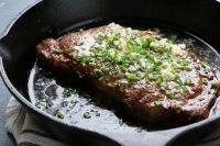 perfectly cooked broiled steak in cast iron pan