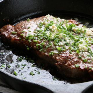 perfectly cooked broiled steak in cast iron pan