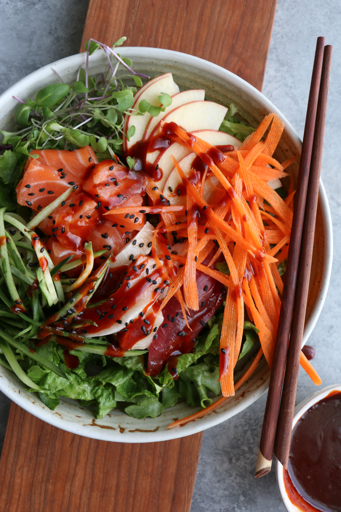 Sashimi Salad Bowl! Sliced sashimi over a bed of lettuce with fresh cucumbers, carrots, thinly sliced apples, micro greens and topped with a spicy gochujang sauce! So fresh and delicious!