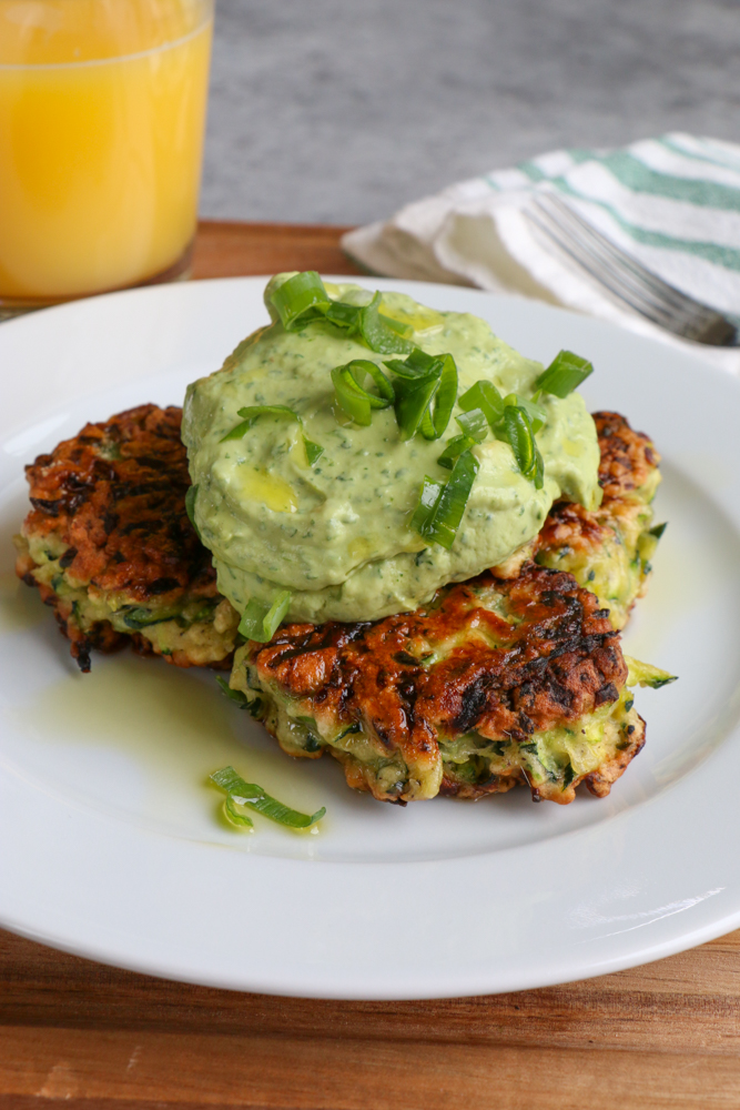 Zucchini Fritters with Avocado Crema!! Brunch with a healthy twist! Savory and delicious and topped with a fresh avocado crema!
