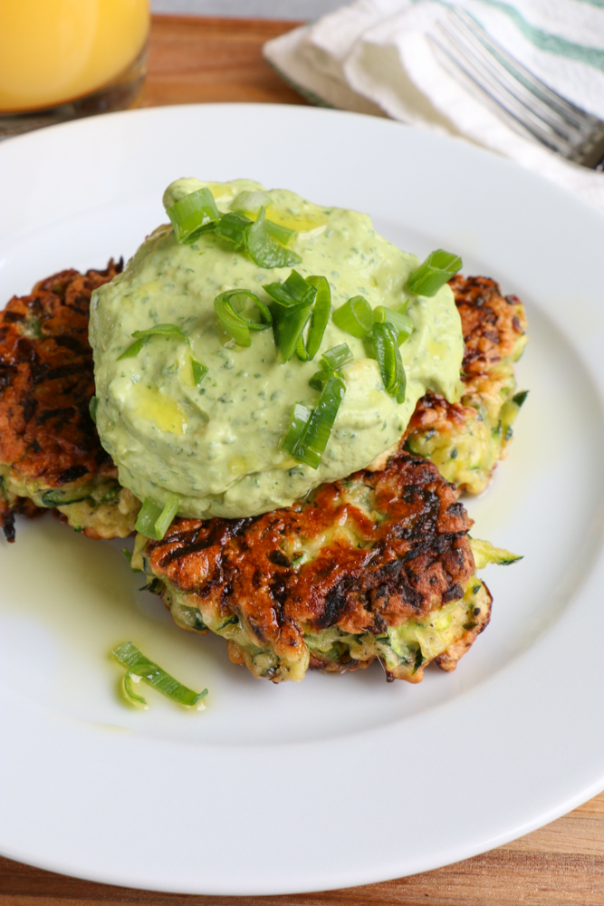 Zucchini Fritters with Avocado Crema!! Brunch with a healthy twist! Savory and delicious and topped with a fresh avocado crema!