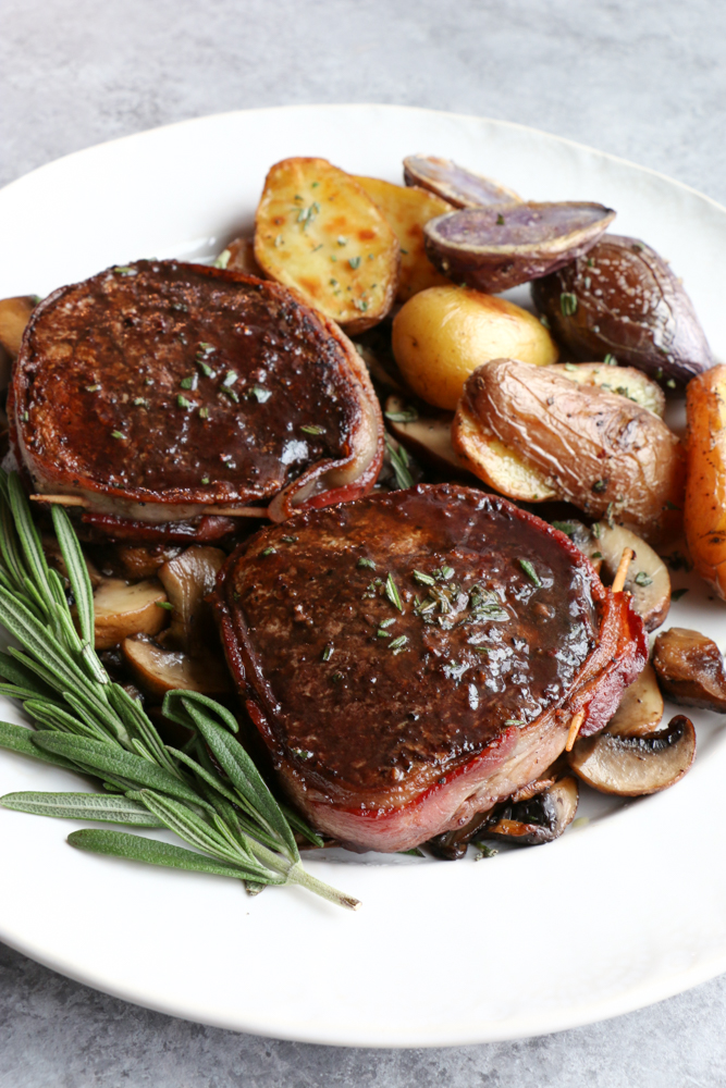 How To Cook Beef Tenderloin at home! Looking for a special recipe to make over the holidays? Wrapped in bacon and with a Pinot Noir Sauce!