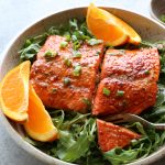 Salmon with Spicy Citrus Dressing. Baked salmon with a delicious, slightly spicy, citrusy dressing, served over fresh spinach and arugula.
